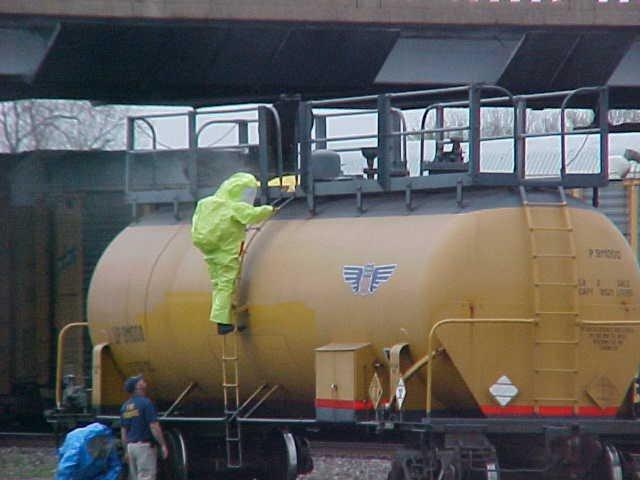 Fire fighter learning how to maneuver around a dangerous rail car.